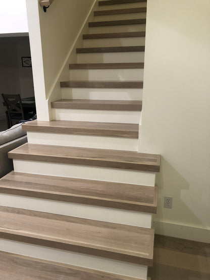Modern retrofit stair treads in light hardwood with white risers on an interior staircase